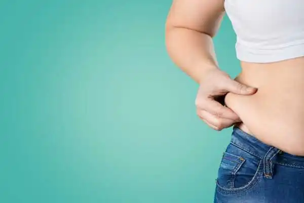 Image of woman pinching her love handles to show weight gain Winslow